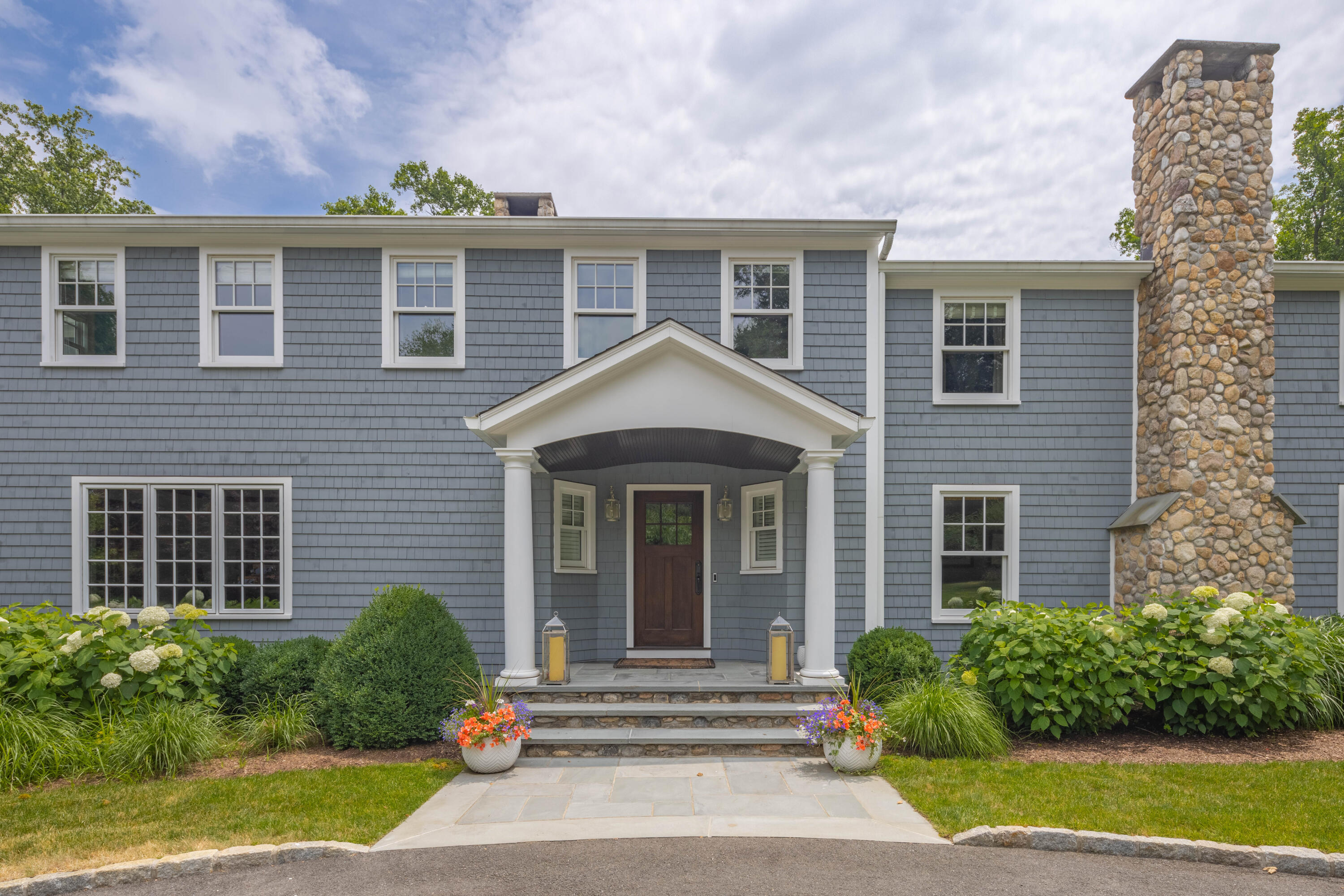 8 Hanson Road Darien, CT 06820 - Photo 36 of 38 a front view of a house with a yard and potted plants