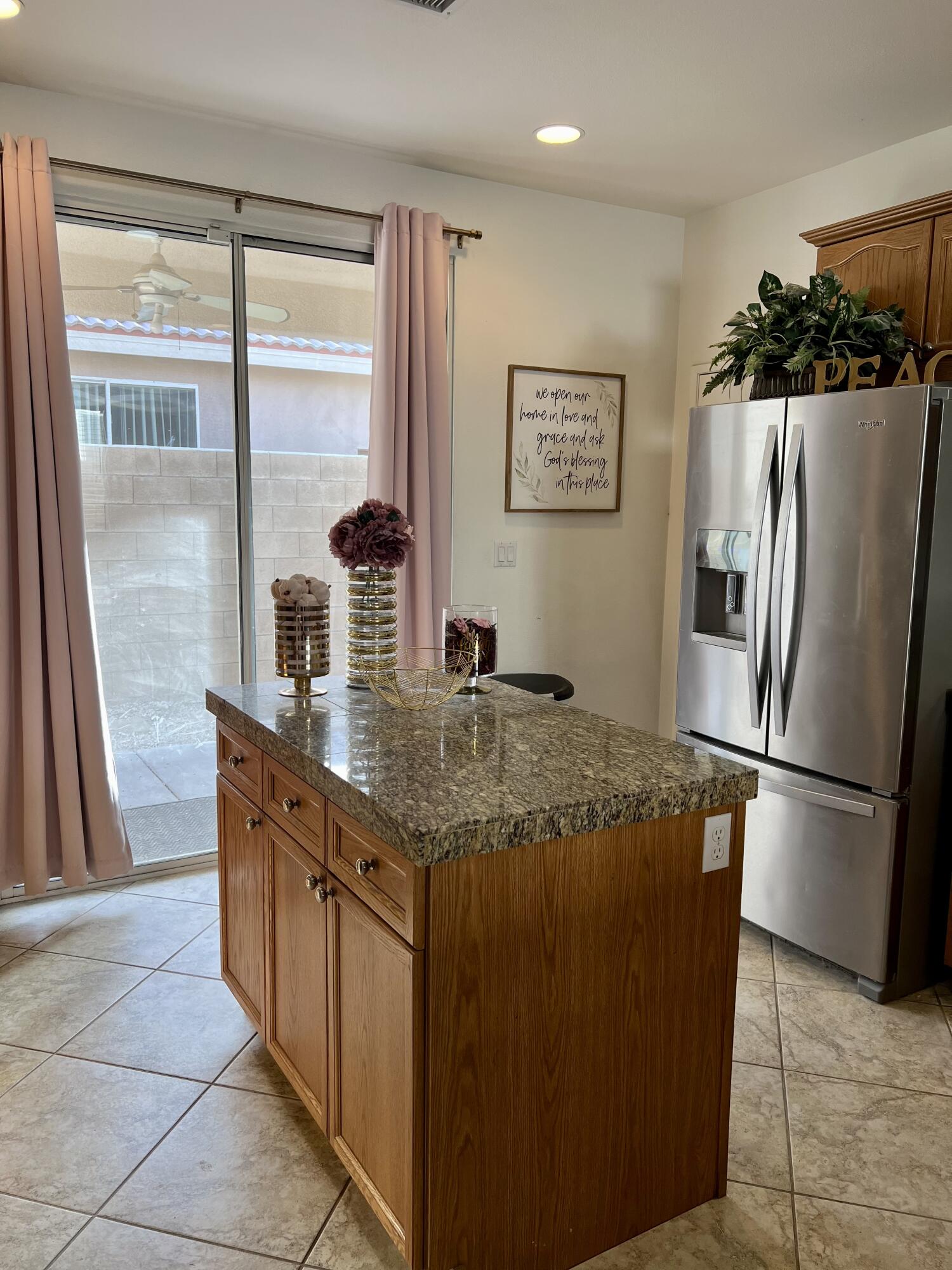 46450 Calle Raphael Indio, CA 92201 - Photo 13 of 33 a kitchen with stainless steel appliances granite countertop a refrigerator a sink and a large window