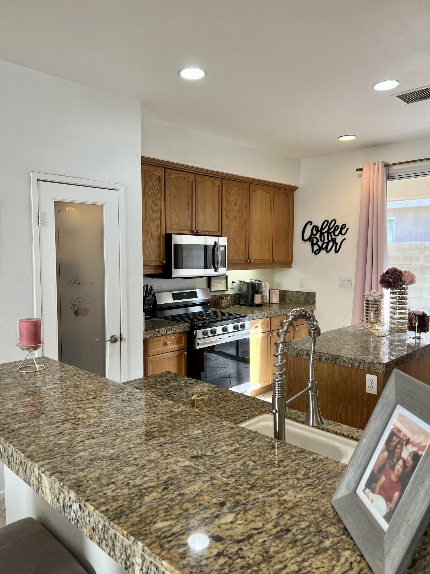 46450 Calle Raphael Indio, CA 92201 - Photo 10 of 33 a kitchen with stainless steel appliances granite countertop a stove top oven a sink a dining table and chairs