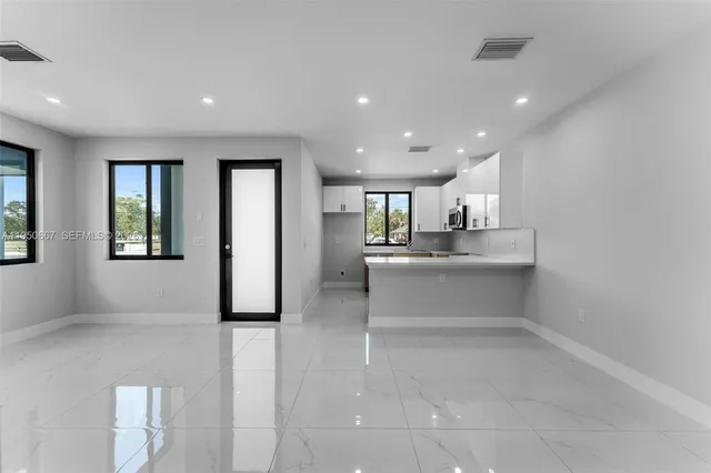 a large white kitchen with white cabinets and a sink