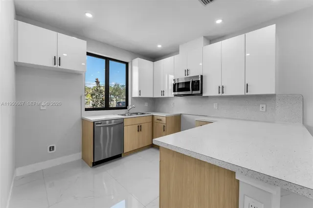 a kitchen with a sink a microwave and cabinets