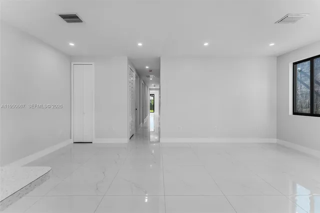 an empty room with windows and closet