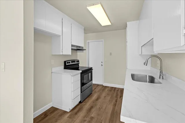 a kitchen with sink a microwave and cabinets