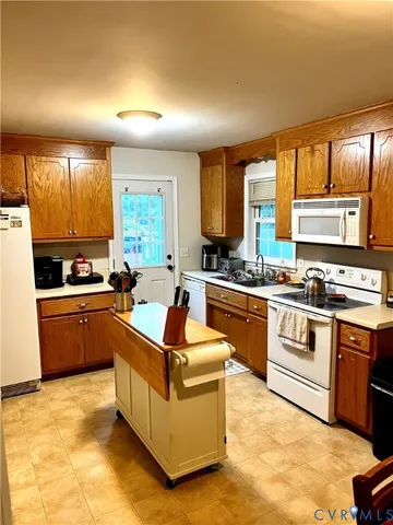 a kitchen with stainless steel appliances kitchen island granite countertop a stove a sink and a refrigerator