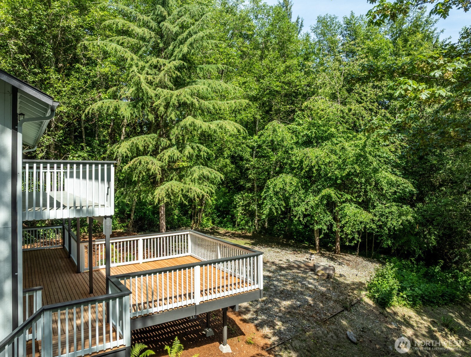 7605 Northeast Hidden Cove Road Bainbridge Island, WA 98110 - Photo 21 of 36 a view of balcony with wooden floor and outdoor seating