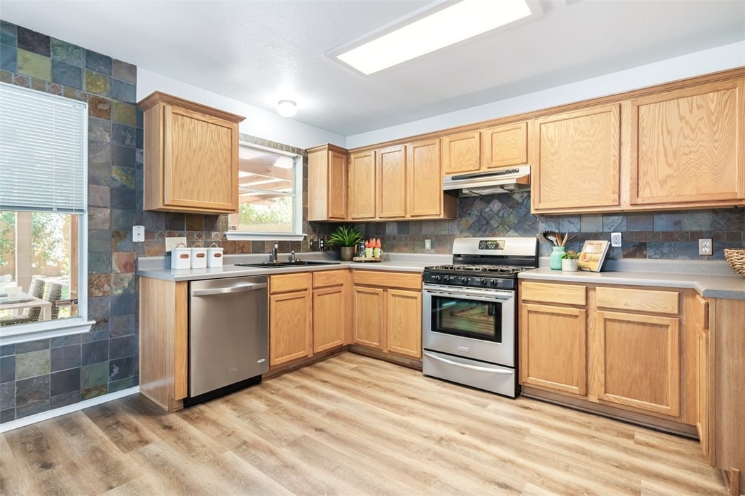 a kitchen with granite countertop a stove a sink and a microwave