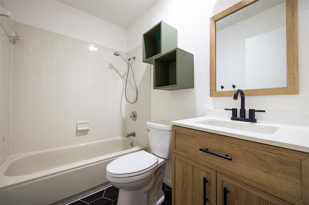 812 Sherbrook Drive Richardson, TX 75080 - Photo 19 of 28 a bathroom with a sink toilet a mirror and shower