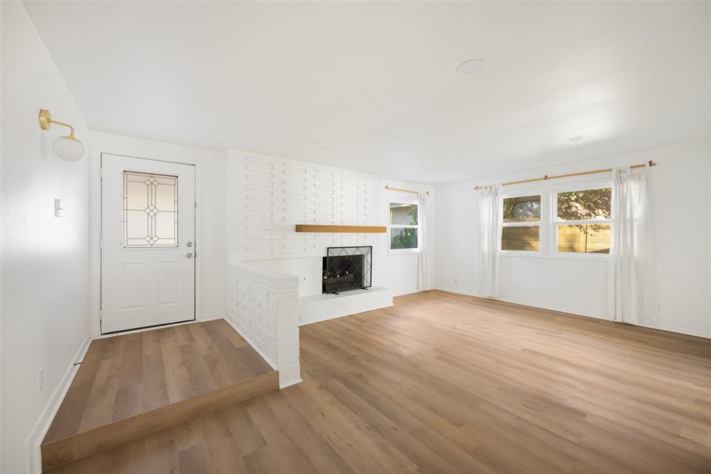 812 Sherbrook Drive Richardson, TX 75080 - Photo 3 of 28 an empty room with windows and fireplace