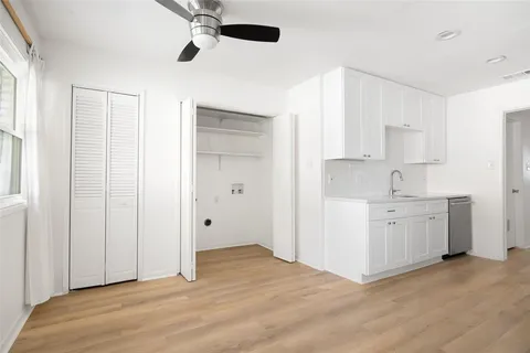 a view of an empty room with window and cabinet