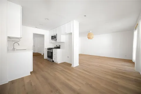 a view of a kitchen with a sink dishwasher oven and cabinets