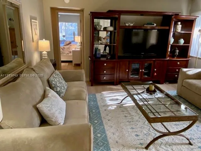 a living room with furniture a rug and a flat screen tv