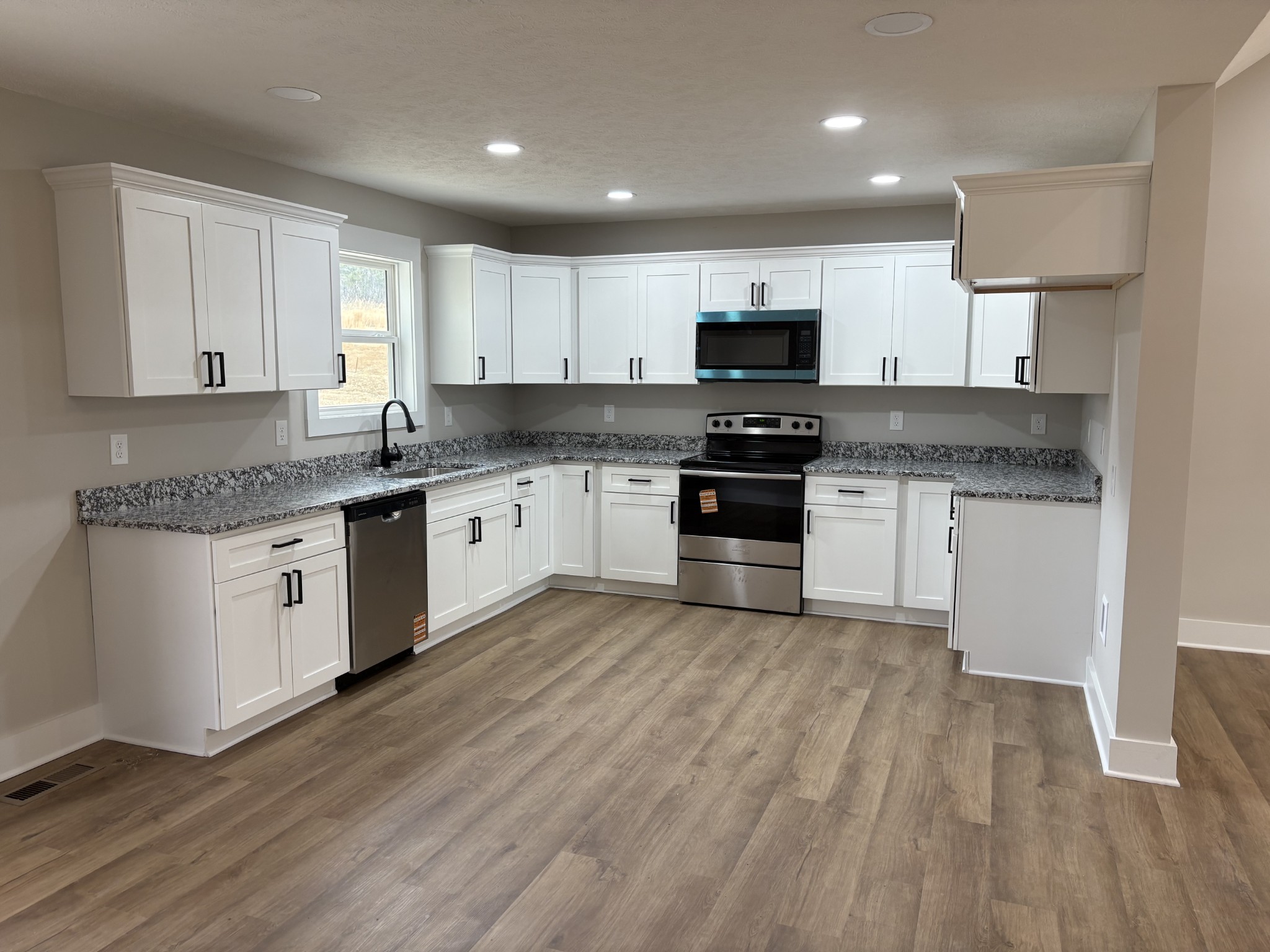 2264 Collier Road Cornersville, TN 37047 - Photo 12 of 20 a kitchen with stainless steel appliances granite countertop a stove top oven a sink dishwasher and a microwave oven on the wooden floor