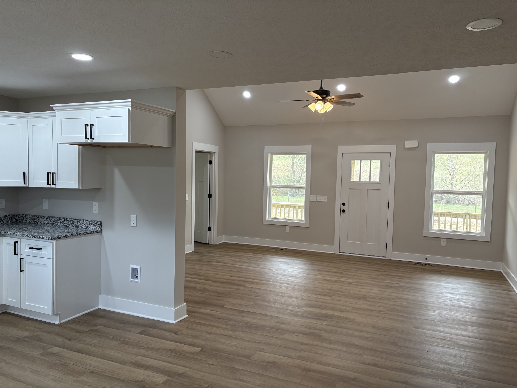 2264 Collier Road Cornersville, TN 37047 - Photo 13 of 20 an empty room with wooden floor a ceiling fan and kitchen view
