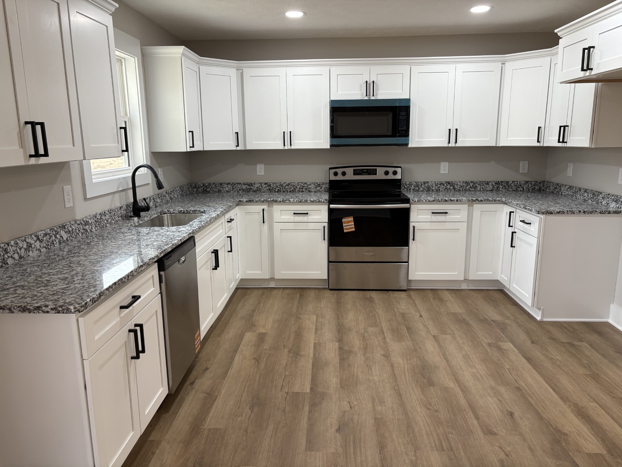 2264 Collier Road Cornersville, TN 37047 - Photo 10 of 20 a kitchen with granite countertop white cabinets and stainless steel appliances