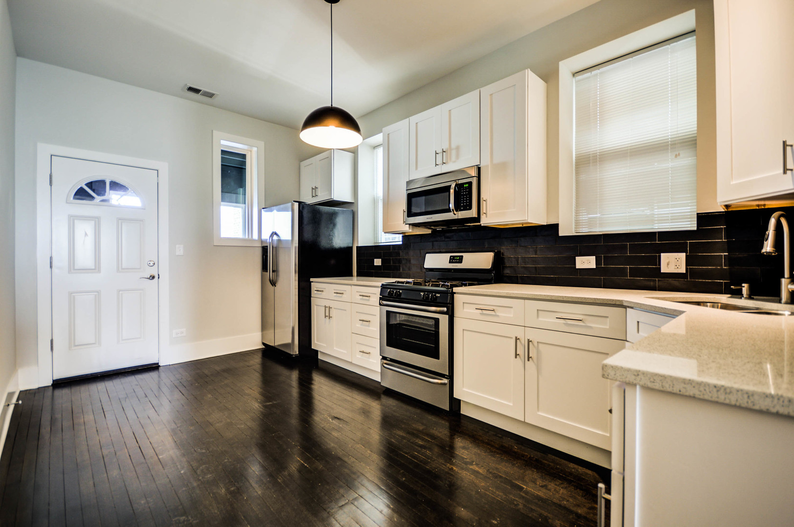 1724 West 21st Street, Unit 3F Chicago, IL 60608 - Photo 4 of 13 a kitchen with stainless steel appliances granite countertop a stove a sink a refrigerator a microwave oven a refrigerator with white cabinets and wooden floor