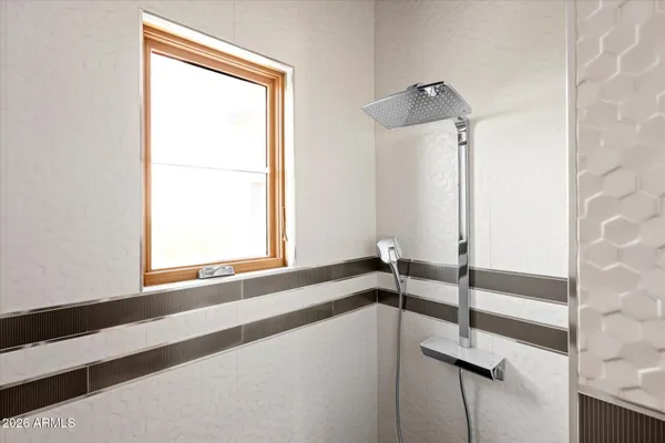 a spacious bedroom with a bed windows and a chandelier