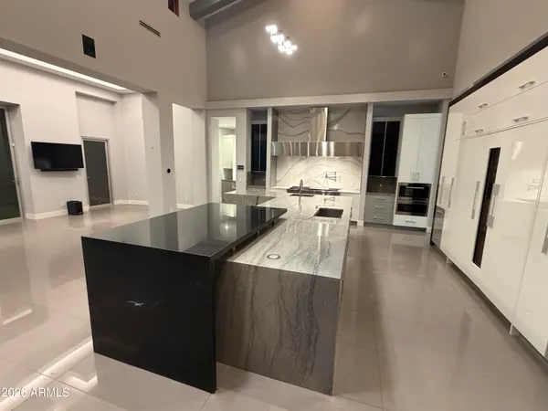 a large kitchen with kitchen island granite countertop a large counter top and stainless steel appliances