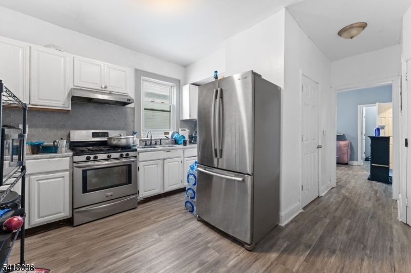 907 Flora Street Elizabeth, NJ 07201 - Photo 14 of 24 a kitchen with a refrigerator stove and white cabinets