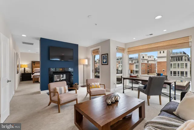 a living room with furniture a large window and wooden floor
