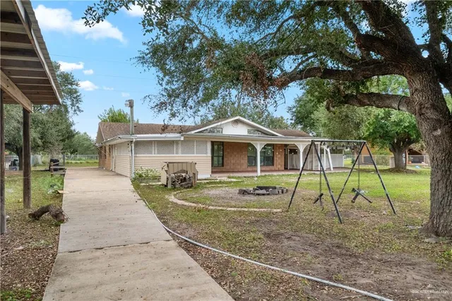 a backyard of a house with table and chairs