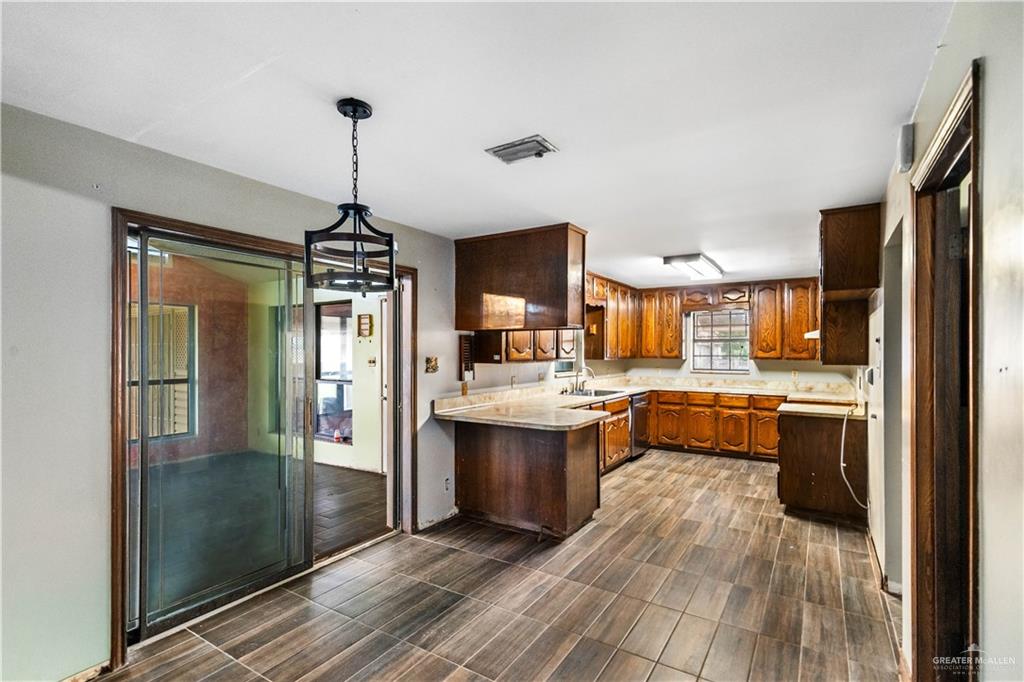7654 East Alberta Road Edinburg, TX 78542 - Photo 7 of 33 a kitchen with stainless steel appliances granite countertop a refrigerator a sink dishwasher a stove and a dining table with wooden floor