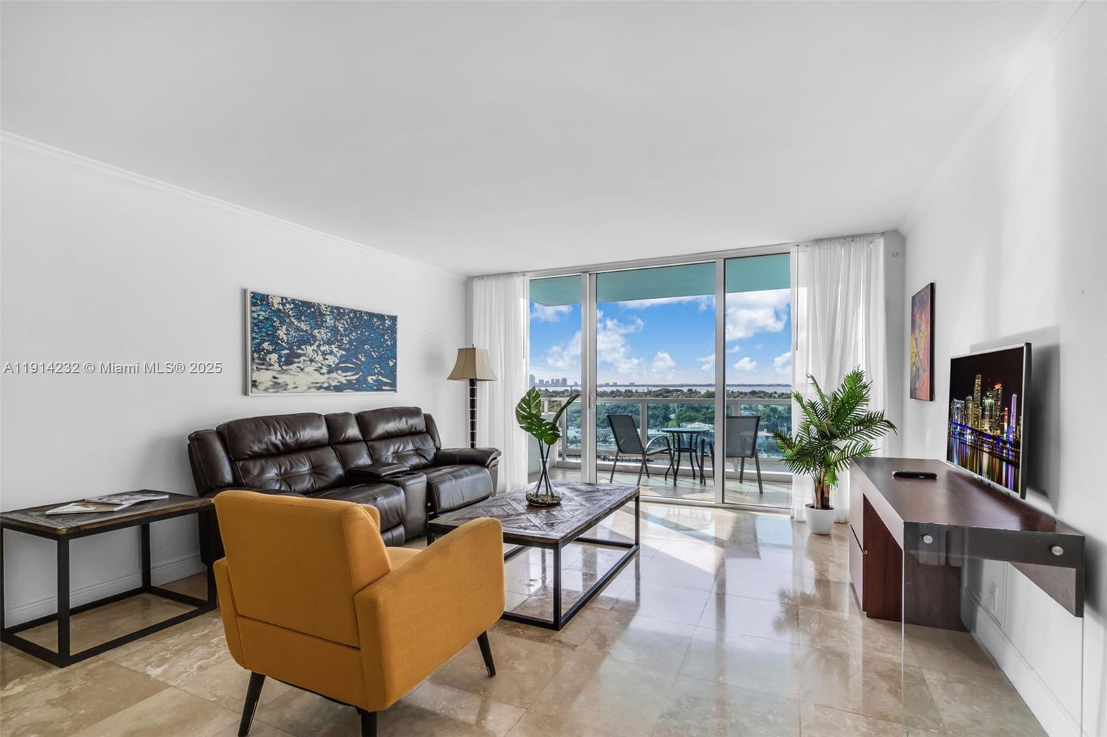 5101 Collins Avenue, Unit 12U Miami Beach, FL 33140 - Photo 2 of 26 a living room with furniture potted plant and a large window