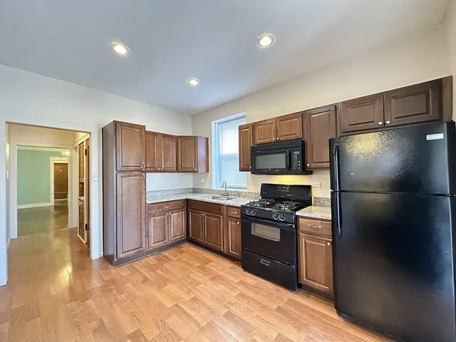 a kitchen with stainless steel appliances granite countertop a refrigerator and a stove top oven
