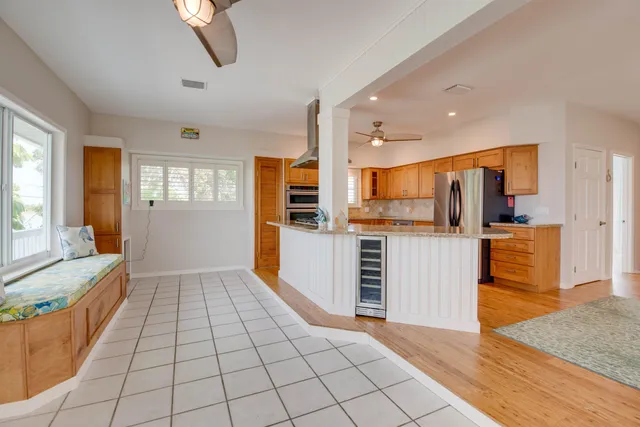 a view of a kitchen with kitchen island granite countertop wooden floor and stainless steel appliances