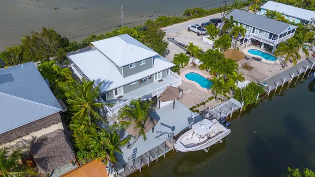 an aerial view of a house with garden space and a swimming pool