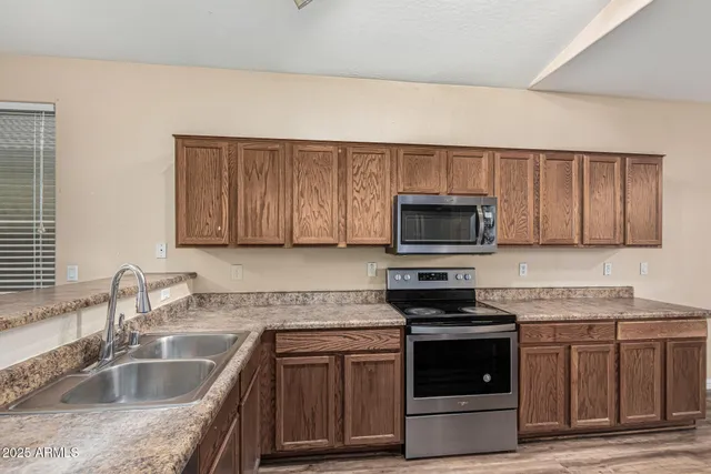 a kitchen with granite countertop a sink and steel appliances