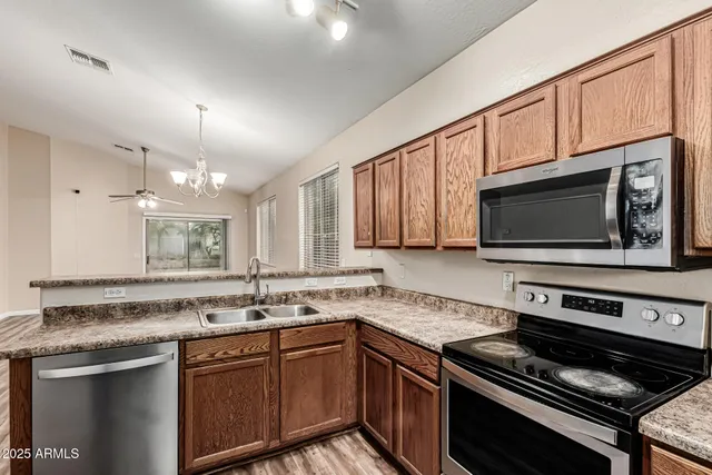 a kitchen with stainless steel appliances a sink stove and microwave