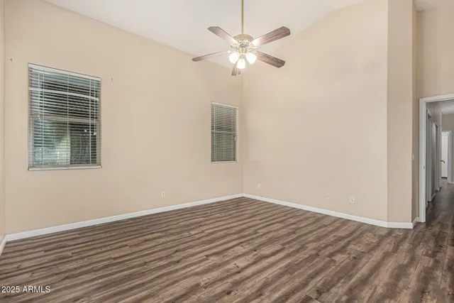 a view of a room with wooden floor and a ceiling fan