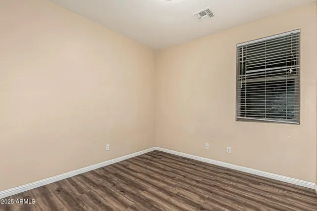 a view of a room with wooden floor and a window