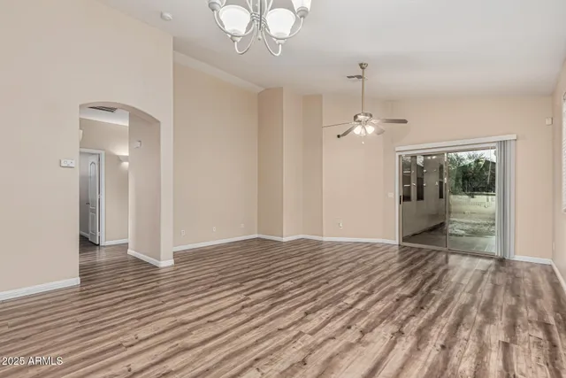 a view of a livingroom with wooden floor and a chandelier