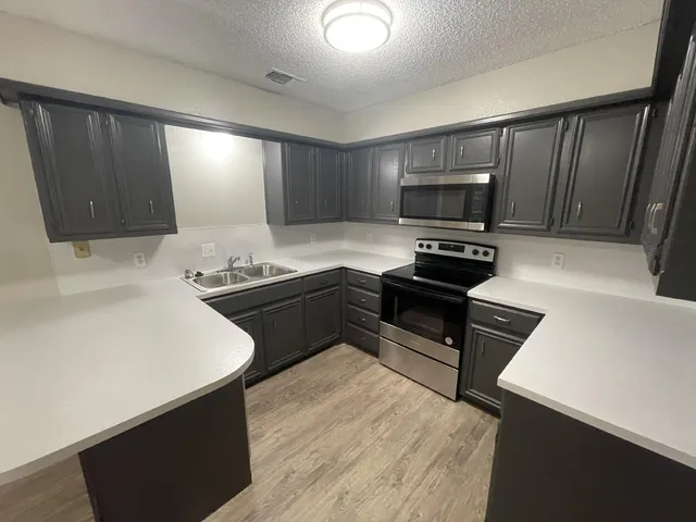 a kitchen with a refrigerator and a stove top oven