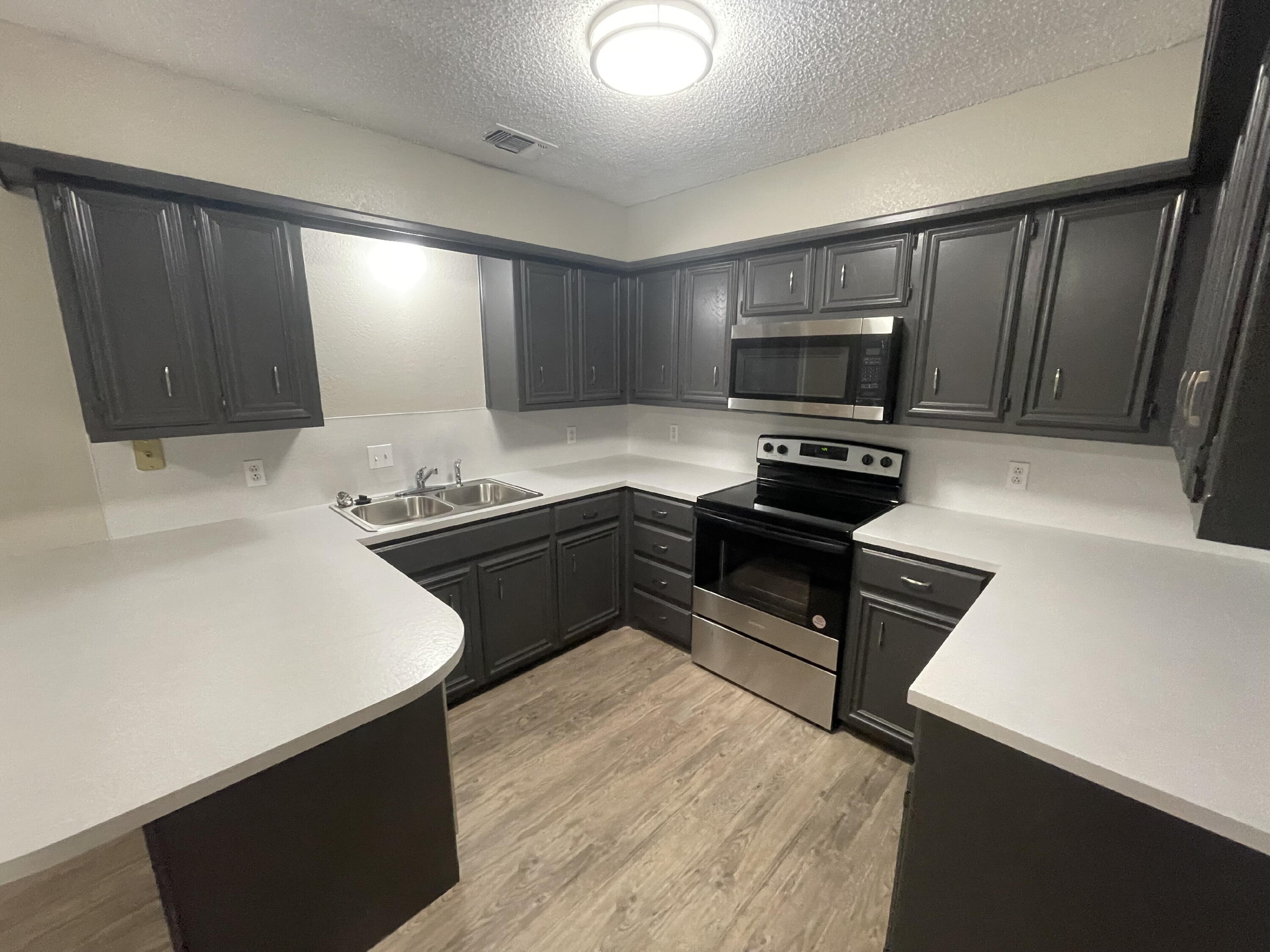 6724 4th Street, Unit A Lubbock, TX 79416 - Photo 4 of 9 a kitchen with a refrigerator and a stove top oven