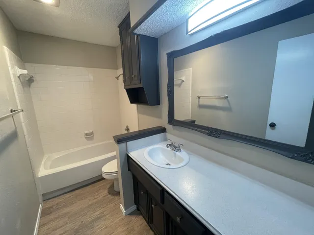 a bathroom with a sink a tub and a mirror