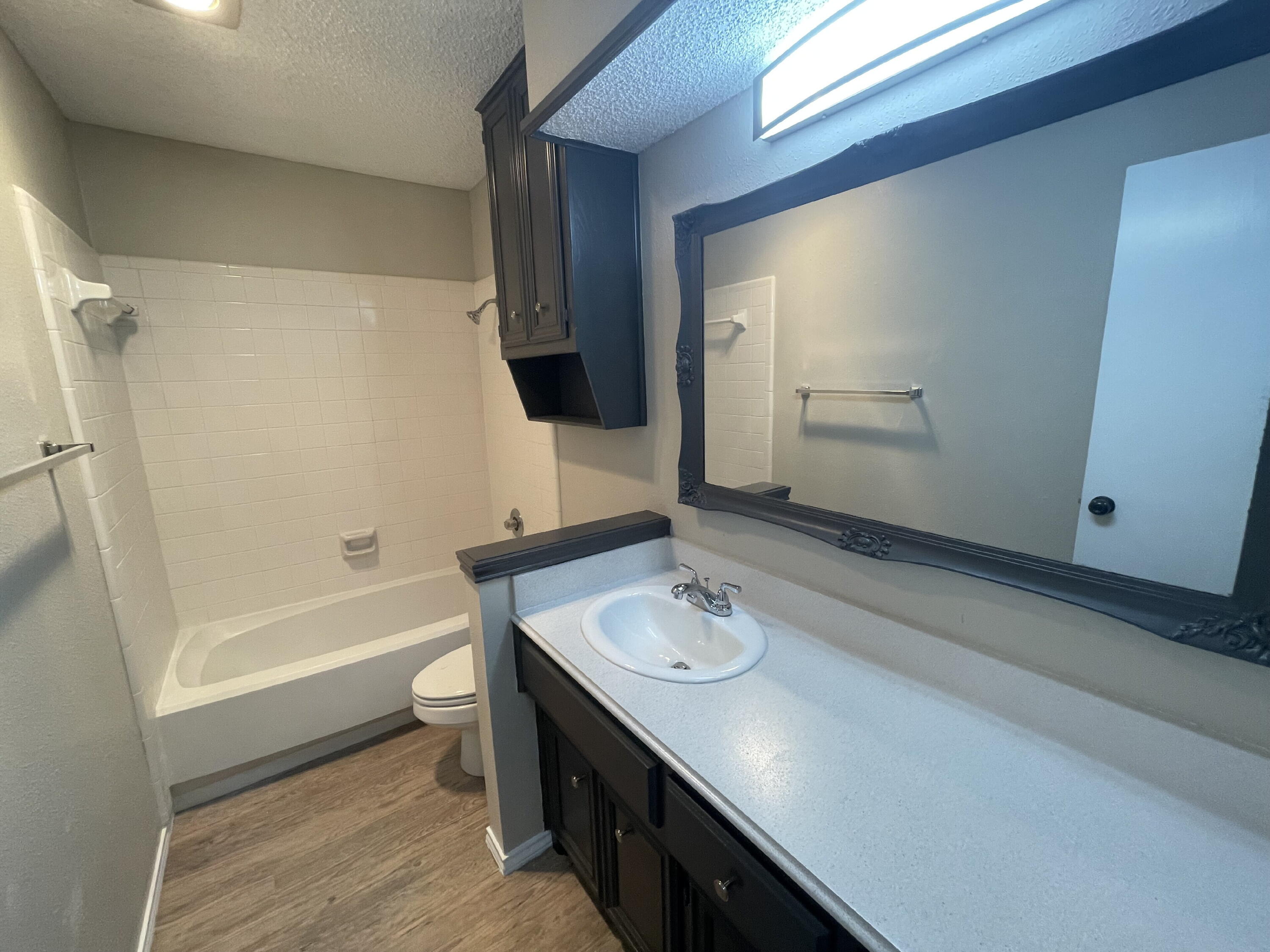 6724 4th Street, Unit A Lubbock, TX 79416 - Photo 6 of 9 a bathroom with a sink a tub and a mirror