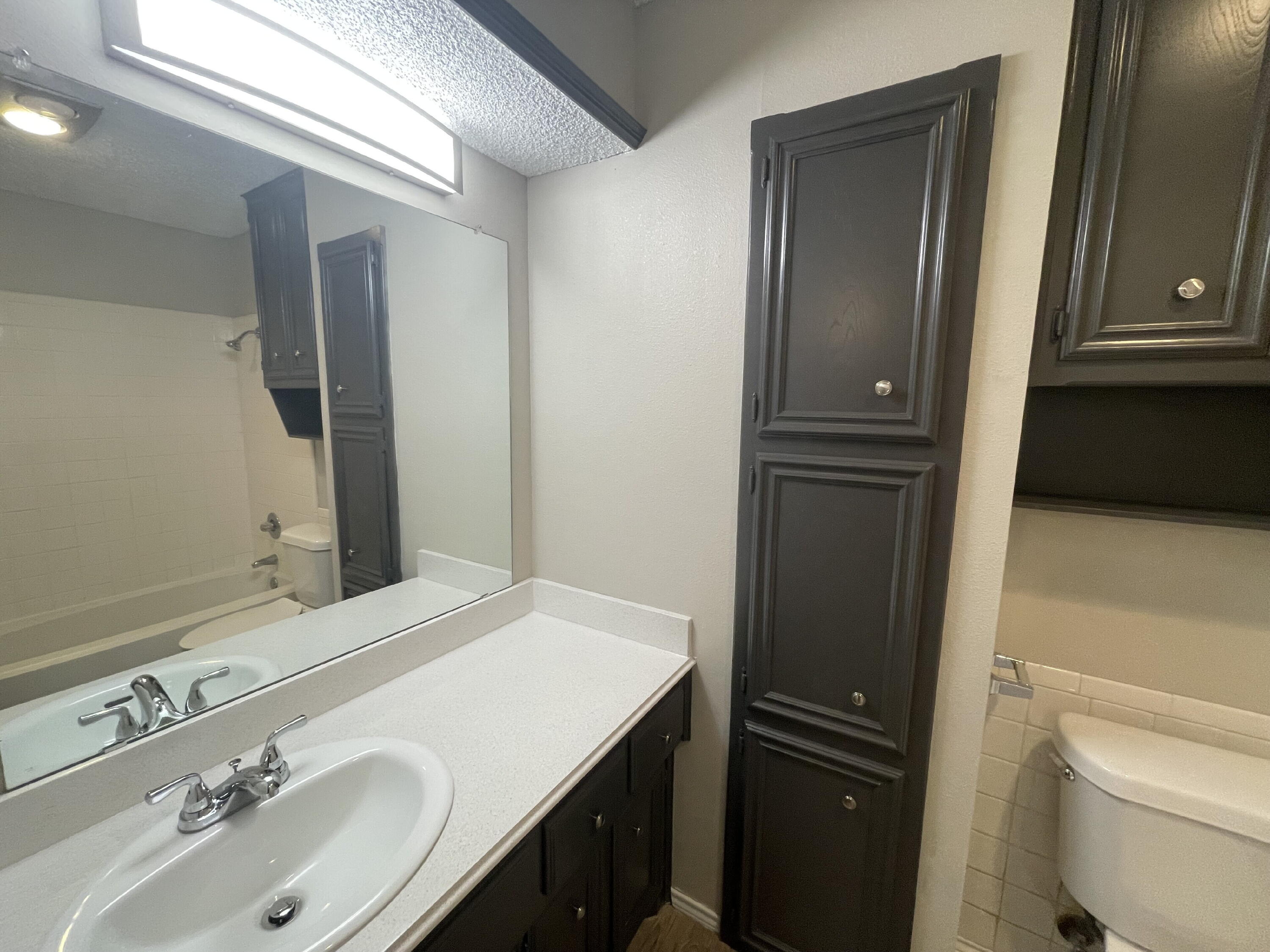 6724 4th Street, Unit A Lubbock, TX 79416 - Photo 8 of 9 a bathroom with a sink and a mirror