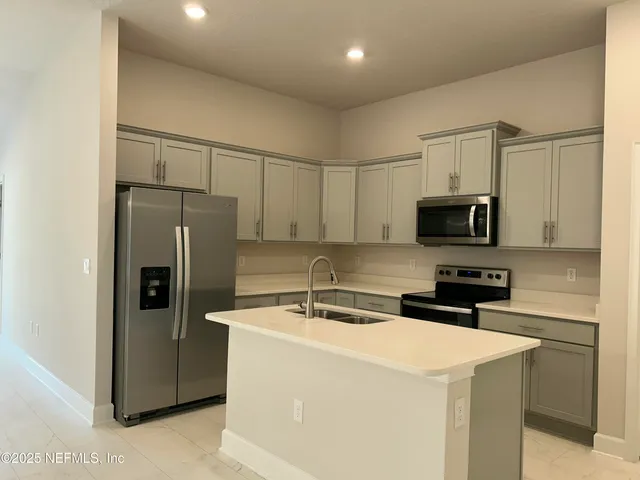 a kitchen with stainless steel appliances a refrigerator stove microwave and sink