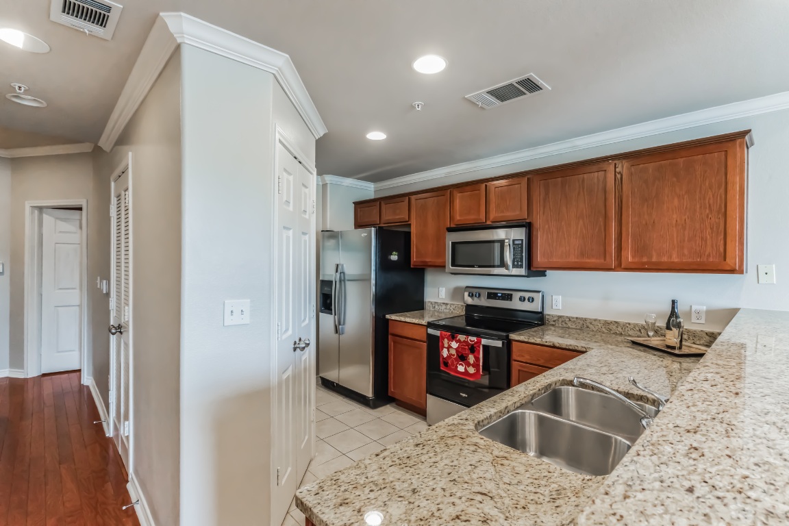 305 East 31st Street, Unit 6 Austin, TX 78705 - Photo 5 of 26 a kitchen with stainless steel appliances granite countertop a refrigerator and a sink