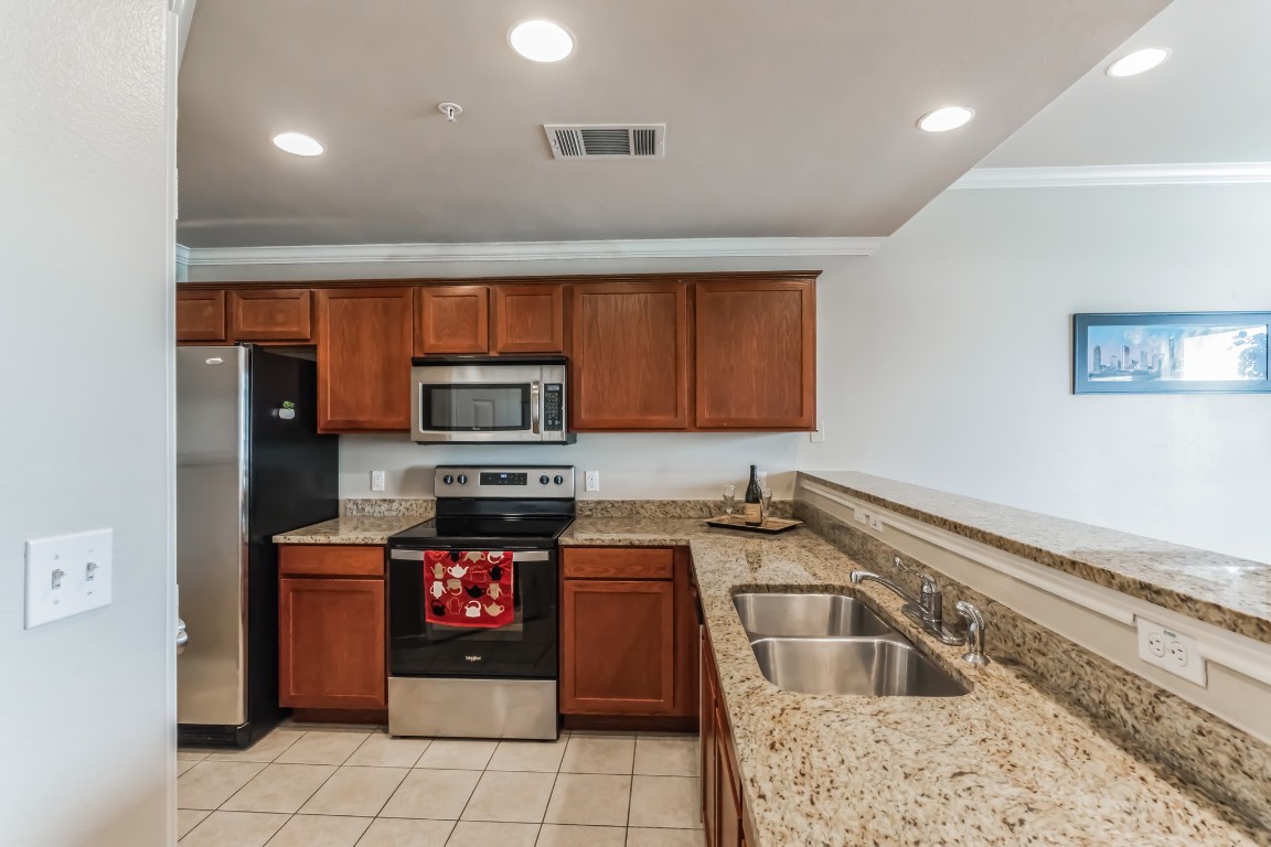 305 East 31st Street, Unit 6 Austin, TX 78705 - Photo 6 of 26 a kitchen with stainless steel appliances granite countertop a stove a sink and a microwave