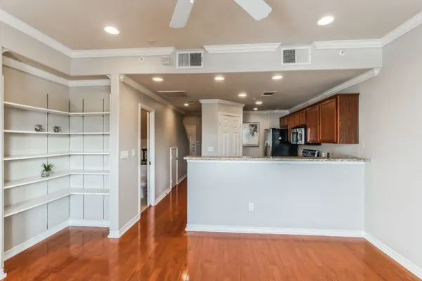 a view of kitchen and kitchen with stainless steel appliances wooden floor