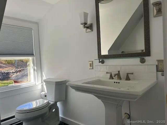 a bathroom with a sink a toilet and mirror