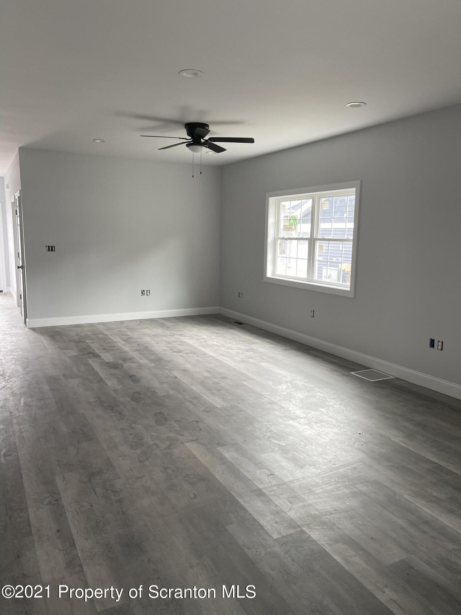 420 Felts Street Taylor, PA 18517 - Photo 2 of 9 an empty room with windows and ceiling fan