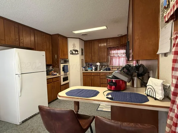 a kitchen with stainless steel appliances granite countertop a refrigerator a stove a sink dishwasher and white countertops with wooden floor