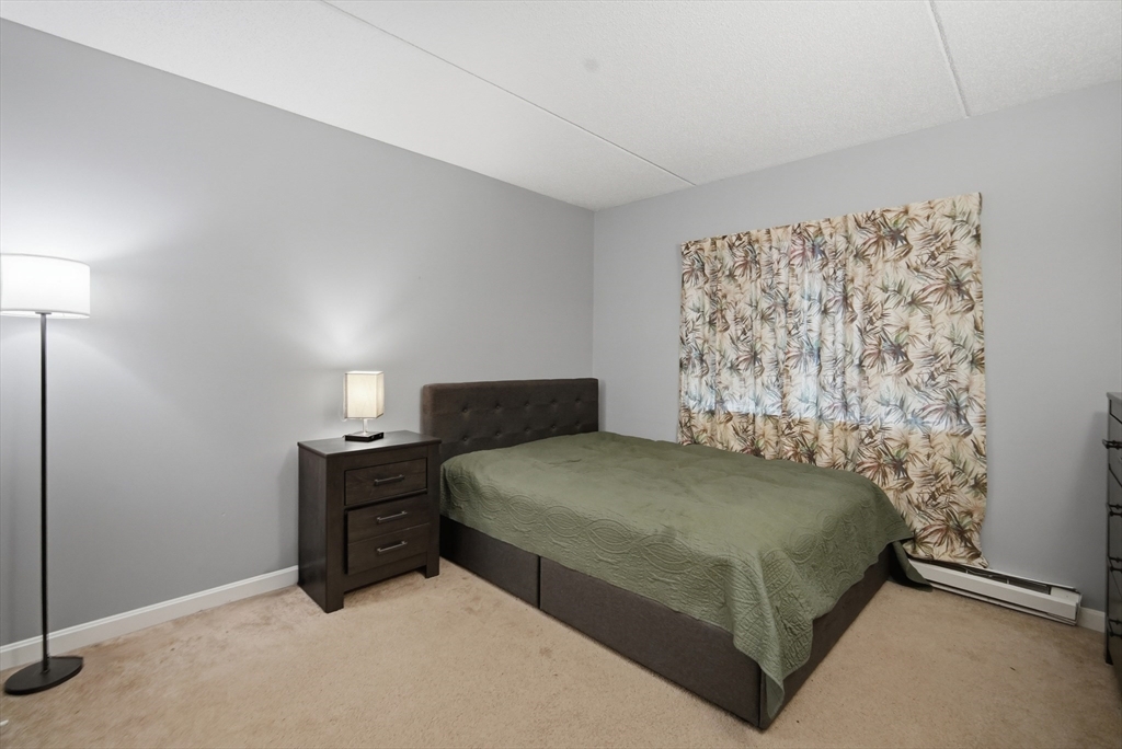 36 Maple Crest Circle, Unit F Holyoke, MA 01040 - Photo 14 of 16 a bedroom with a bed and a lamp on the dresser