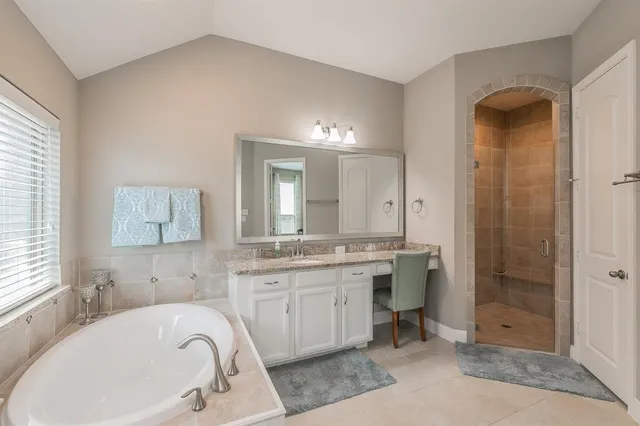 a bathroom with a tub sink and mirror