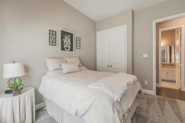 a bedroom with a bed and painting on the wall