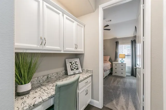 a kitchen with a white cabinets and potted plant